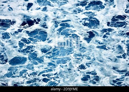 Raues Meer aus nächster Nähe. Schöne blaue Wellen mit viel Meeresschaum-Szene von oben aus der Nähe. Schaum auf dem blauen Meer. Beauty-Welt. Stockfoto
