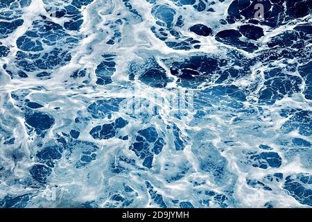 Raues Meer aus nächster Nähe. Schöne blaue Wellen mit viel Meeresschaum-Szene von oben aus der Nähe. Schaum auf dem blauen Meer. Beauty-Welt. Stockfoto