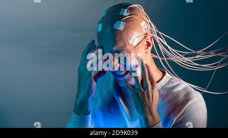 Person mit Implantaten im Kopf erlebt Stress und Schrecken. Neue Technologien, Augmented Brain, Neuroschnittstelle und Virtualität. Stockfoto