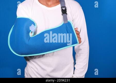 Junger Mann trägt eine Armstütze für gebrochene Hand. Stockfoto