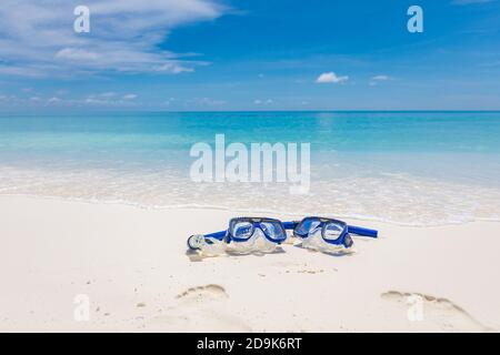 Zwei Masken und Schnorchelausrüstung in den Wellen des Sandstrandes. Exotische Outdoor-Sport-Aktivität, Freizeit-Hobby. Blick auf den Strand und die Landschaft Stockfoto