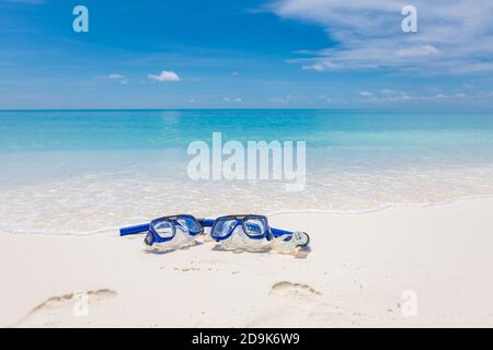 Zwei Masken und Schnorchelausrüstung in den Wellen des Sandstrandes. Exotische Outdoor-Sport-Aktivität, Freizeit-Hobby. Blick auf den Strand und die Landschaft Stockfoto