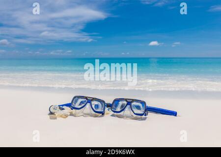 Zwei Masken und Schnorchelausrüstung in den Wellen des Sandstrandes. Exotische Outdoor-Sport-Aktivität, Freizeit-Hobby. Blick auf den Strand und die Landschaft Stockfoto