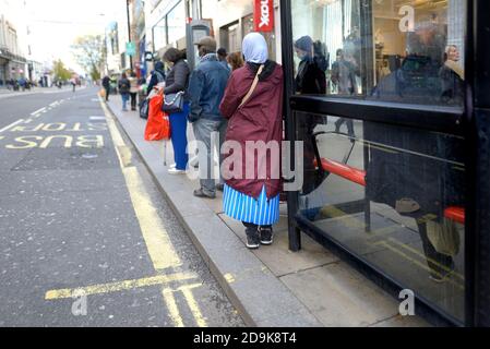 London, England, Großbritannien. Leute, die an einer Bushaltestelle in der Oxford Street warten Stockfoto