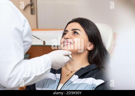 Junge Frau mit herrlichem Lächeln auf Zahnarzt, Blick auf den Arzt Stockfoto