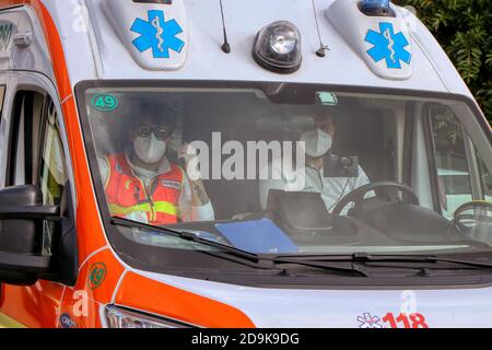 Ärzte mit Schutzmaske in einem italienischen Krankenwagen wegen Das Coronavirus Covid-19 Stockfoto