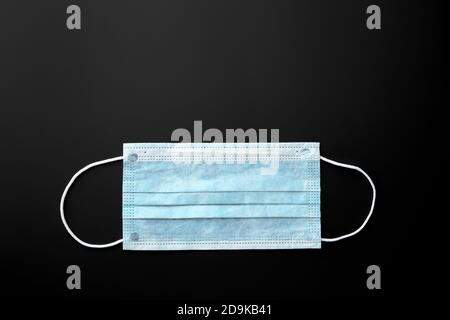 Medizinische Maske, medizinische Schutzmaske auf schwarzem Hintergrund. Einweg-OP-Gesichtsmaske decken den Mund und die Nase. Gesundheitswesen und medizinisches Konzept. Stockfoto