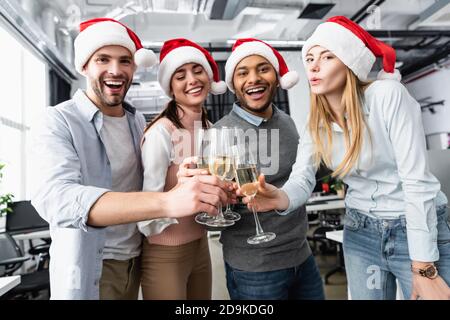 Multiethnische Geschäftsleute lächeln, während sie im neuen Jahr mit Champagner klirren Im Büro Stockfoto