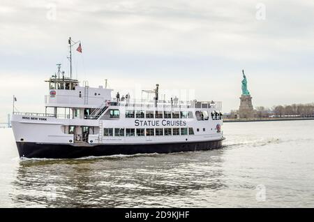 Statue Cruises Fähre Boot mit Touristen und Besuchern mit Freiheitsstatue im Hintergrund. Manhattan, New York City, USA Stockfoto