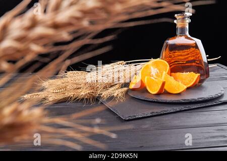 Nahaufnahme von Weizen- und Cognac-Ohren mit orangefarbenen Scheiben. Stockfoto