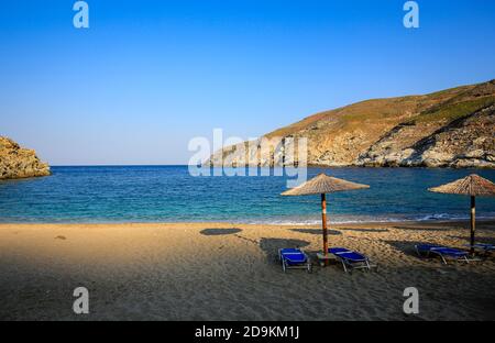 Andros Island, Kykladen, Griechenland - Liegen und Sonnenschirme am Ormos Zorkou Strand im Norden der Insel. Stockfoto