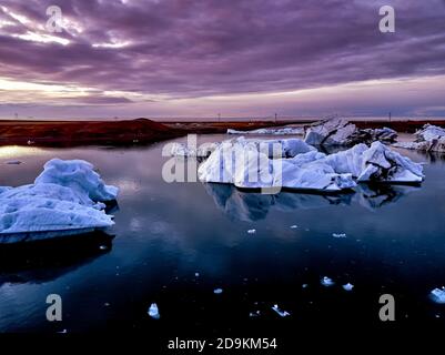 Luftaufnahme der Gletscherlagune in Island während des Sonnenaufgangs. Eisschollen kalbten vom Gletscher. Schmelzendes Eis Stockfoto