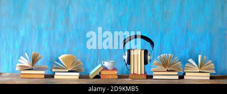 Hörbuch-Konzept mit offenen Büchern, Tasse Kaffee und Vintage-Kopfhörer, Panorama, guter Kopieplatz Stockfoto