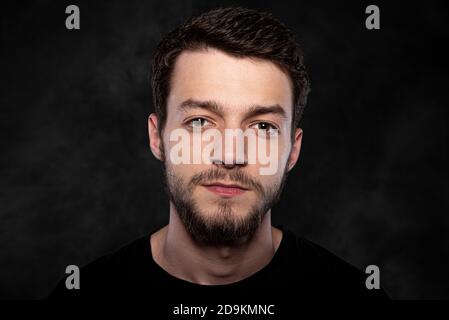 Porträt eines jungen Mannes auf dunklem Hintergrund Stockfoto
