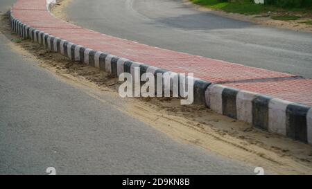 Pink Road Divider in einer Landstraße in Indien. Straße mit Fahrspur Trenner und Barrieren, um den Verkehr zu erleichtern. Stockfoto