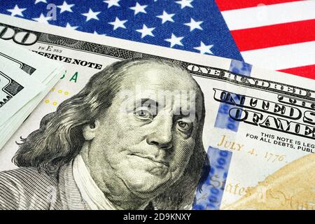 US-Flagge und Dollar-Scheine als Symbol der Stimulus-Check von Cares handeln. Stockfoto