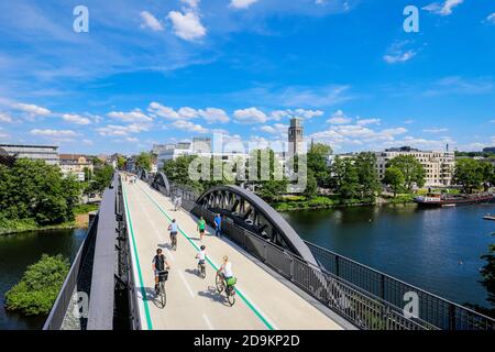 Mülheim an der Ruhr, Ruhrgebiet, Nordrhein-Westfalen, Deutschland, Radschnellweg Ruhr RS1, führt in Mülheim auf einer ehemaligen Eisenbahnbrücke über das Ruhrgebiet, hinter dem Rathausturm. Stockfoto