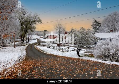 Walpole, New Hampshire, USA. 2020. Autmn Blätter bedecken eine Autobahn und Schnee bedeckt die Landschaft in New Hampshire. Stockfoto