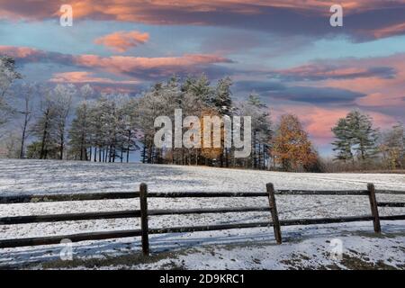 Walpole, New Hampshire, USA. 2020. Ein leichter Schneefall bedeckt ein Feld mit einem Hauch von Herbstblättern auf den Bäumen in New Hampshire. Stockfoto