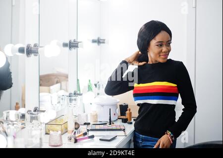 Porträt einer afroamerikanischen Frau, die Make-up auf dem Schönheitssalon anwendet. Stockfoto