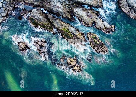 Luftaufnahme der Meereswellen und der felsigen Küste. Gefahr Meereswellen krachen von riesigen Felsen mit Spray und Schaum. Valparaiso, Chile. Stockfoto