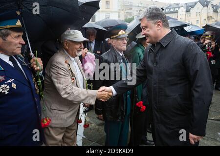 KIEW, UKRAINE - 22. Jun 2015: Präsident der Ukraine Petro Poroschenko, schüttelt die Hände mit Veteranen im Park of Glory in Kiew Stockfoto