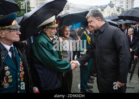 KIEW, UKRAINE - 22. Jun 2015: Präsident der Ukraine Petro Poroschenko, schüttelt die Hände mit Veteranen im Park of Glory in Kiew Stockfoto