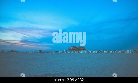 Farbenprächtiger Sonnenuntergang an der Nordsee - im Hintergrund der Sonne ein typisches Stelzenhaus, Pfahlbauten, Pfahlbauten, die den Gezeiten trotzen. Stockfoto