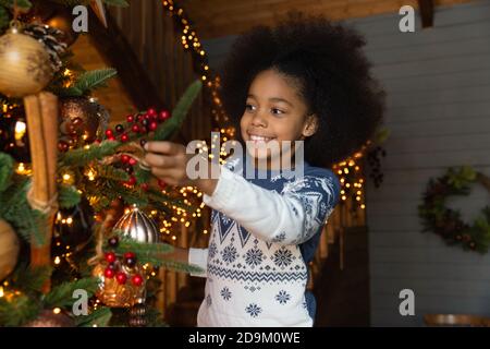 Close up lächelnd afroamerikanische kleine Mädchen Dekoration Weihnachtsbaum Stockfoto