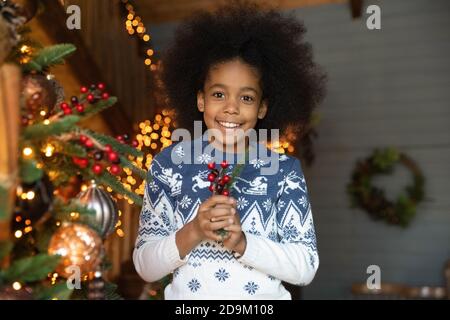 Kopf erschossen Porträt lächelnd afroamerikanische Mädchen hält Weihnachtskugel Stockfoto