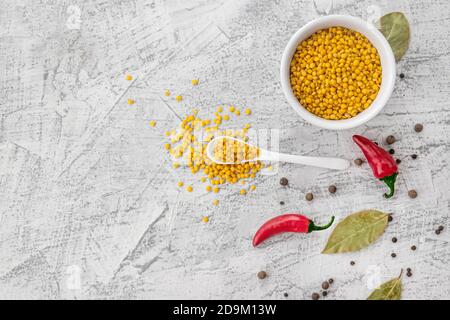 Gelbe Linsen mit Gewürzen auf weißem Hintergrund. Gesunder Lebensstil. Zutaten für Linsensuppe mit Platz zum Kopieren. Flach liegend. Draufsicht. Stockfoto