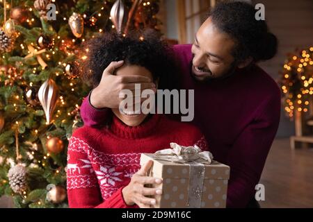 Nahaufnahme afroamerikanischen Mann Vorbereitung Weihnachtsgeschenk für Frau Stockfoto