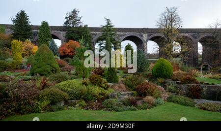 Kilver Court Gardens, historischer Garten unter dem stillliegenden viktorianischen Viadukt, Charlton Viaduct, fotografiert im Herbst mit Blättern, die sich färben. Stockfoto