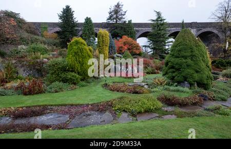 Kilver Court Gardens, historischer Garten unter dem stillliegenden viktorianischen Viadukt, Charlton Viaduct, fotografiert im Herbst mit Blättern, die sich färben. Stockfoto