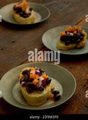 Schwarze Bean Crostini auf kleinen Tellern Stockfoto