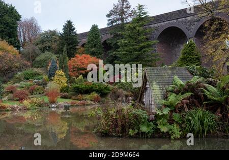 Kilver Court Gardens, historischer Garten am See unter dem stillvollen viktorianischen Charlton Viadukt, fotografiert im Herbst mit sich verfärbendem Laub. Stockfoto