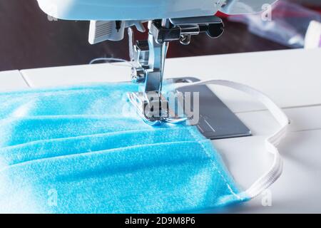 Nähmaschine nähen Hause gemacht diy medizinische wiederverwendbare Schutz Gesichtsmaske mit Nähmaschine zu Hause, so dass Baumwollgewebe medizinische Maske. Coronavirus pan Stockfoto