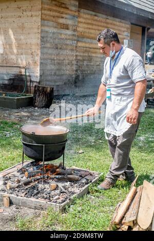 Stadt Sibiu, Rumänien - 26. Juli 2020. Eine unbekannte Person bereitet ein traditionelles rumänisches Essen am Kessel auf dem offenen Feuer zubereitet Stockfoto