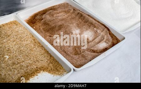 Plastikschalen mit Gewürzen auf dem Tisch Stockfoto