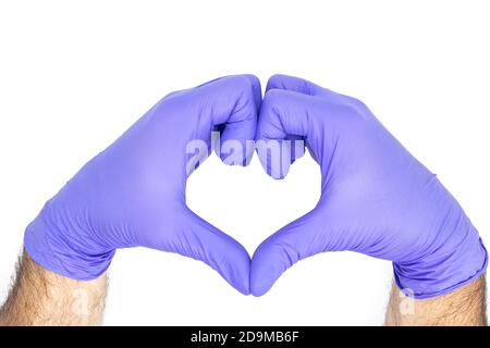 Hände eines Arztes oder einer Krankenschwester mit medizinischen Handschuhen zeigen ein auf weißem Hintergrund isoliertes Herz, Medizinkonzept Stockfoto