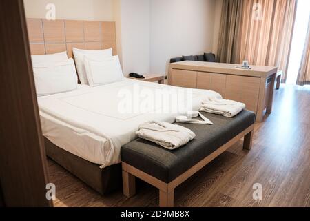 Minimalistisches Design in einem Hotelzimmer. Braune Farben im Schlafzimmer. Komfortable Luxusunterkunft in einem Resort. Junior Suite für Touristen, die reisen.