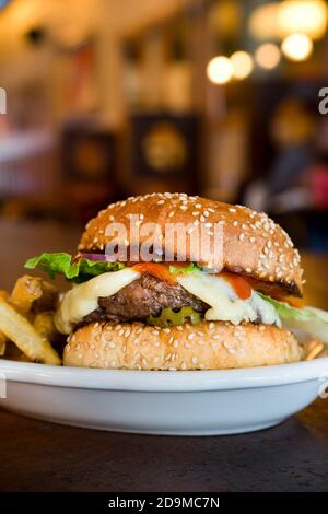 In einem Restaurant werden ausschließlich amerikanische Cheeseburger mit Pommes serviert Stockfoto