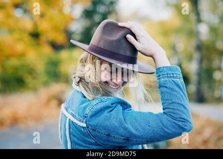 Portrait der Frau stand mit ihrem Hut, der in weht Der Wind Stockfoto