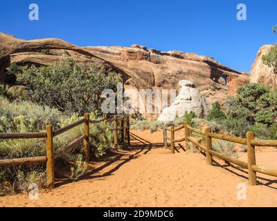 Ein Pfad, der zu einem Ausguspunkt über Landscape und Partition Arch führt, zwei der Bögen des Devils Garden-Abschnitts des Arches-Nationalparks Stockfoto