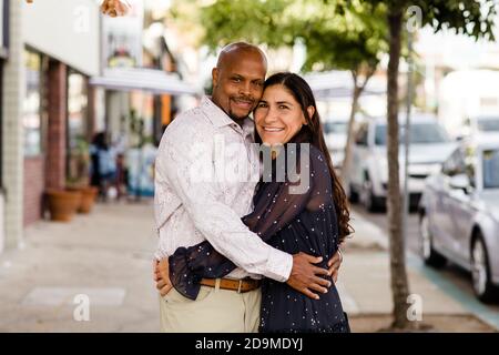 Multirassische Ende der vierziger Jahre Paar umarmt auf San Diego Bürgersteig Stockfoto