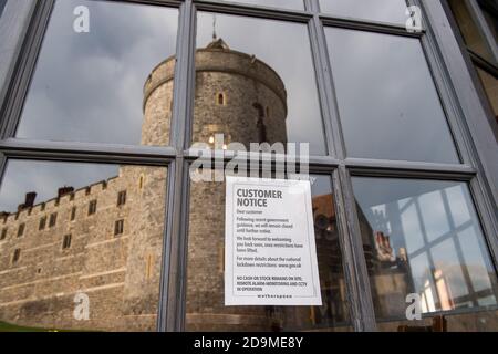 Windsor, Berkshire, Großbritannien. November 2020. Ein geschlossenes Schild im Fenster des Wetherspoon King and Castle Pub mit Spiegelungen des Windsor Castle. Windsor war heute ruhig wie am zweiten Tag der zweiten Covid-19 nationalen Sperre in England. Mehr Geschäfte und Cafés waren geöffnet als in der vorherigen Sperre Anfang dieses Jahres. Quelle: Maureen McLean/Alamy Live News Stockfoto