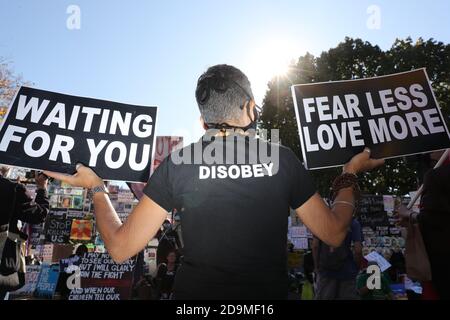 Washington, USA. November 2020. Ein Mann trägt Schilder, die sagen: 'Waiting for You' und 'Fear Less Love More' und trägt ein Hemd mit der Aufschrift 'Disobey', während sich Menschen am Black Lives Matter Plaza vor dem Weißen Haus versammeln, während sie auf das Ergebnis der US-Präsidentschaftswahlen zwischen Präsident Donald Trump warten Und ehemaliger Vizepräsident Joe Biden am 6. November 2020 in Washington. (Foto von Oliver Contreras/SIPA USA) Quelle: SIPA USA/Alamy Live News Stockfoto