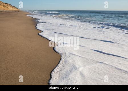 Nahaufnahme der Meereswellen, die den Strandsand von Whitecrest umspülten Strand Stockfoto