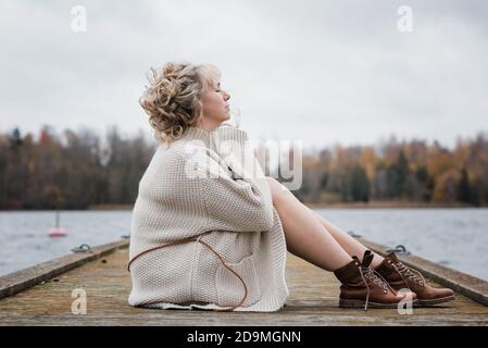 Frau saß draußen atmend in der frischen Luft und sah nachdenklich aus Stockfoto