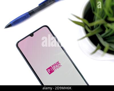 LOD, Israel - 8. Juli 2020: Moderner minimalistischer Büroarbeitsplatz mit schwarzem Smartphone mit Pink Park App Launch Screen mit Logo auf weißem Hintergrund Stockfoto